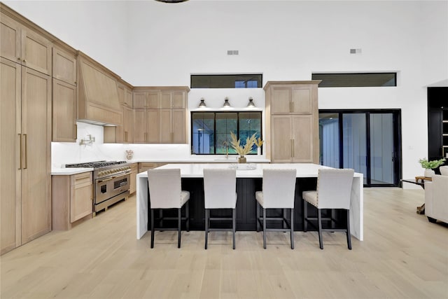 kitchen featuring light countertops, range with two ovens, and a towering ceiling