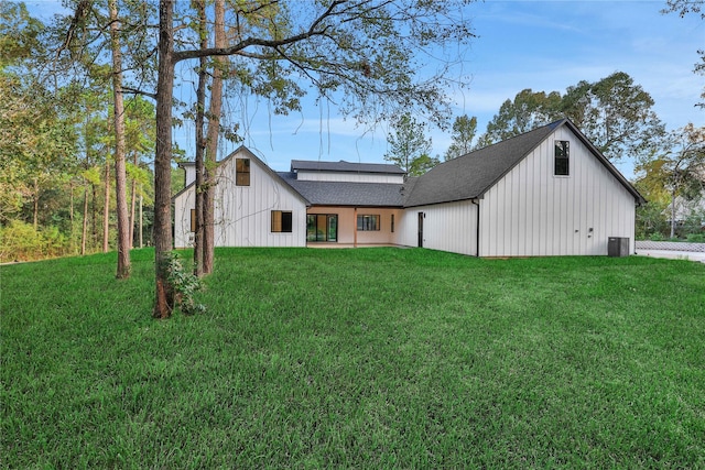 view of front of property with a shingled roof, board and batten siding, and a front yard