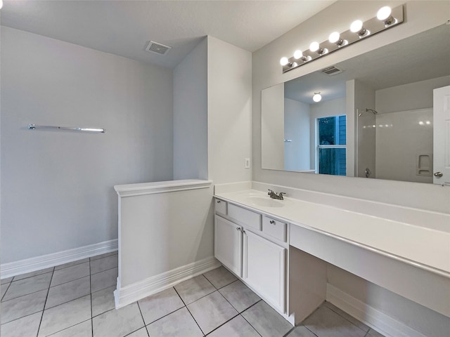 bathroom featuring tile patterned flooring, vanity, and walk in shower