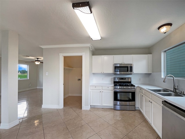 kitchen featuring white cabinetry, stainless steel appliances, sink, and light tile patterned floors