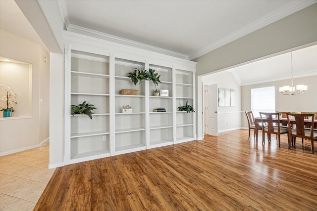 dining room with ornamental molding, an inviting chandelier, and light hardwood / wood-style flooring