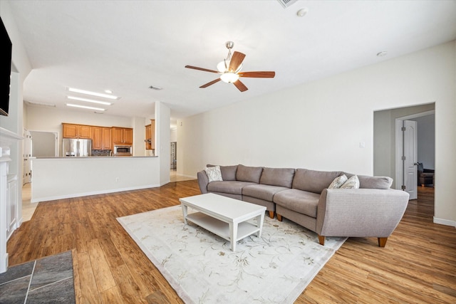 living room with light hardwood / wood-style flooring and ceiling fan