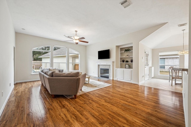 living room with ceiling fan, hardwood / wood-style floors, and built in features