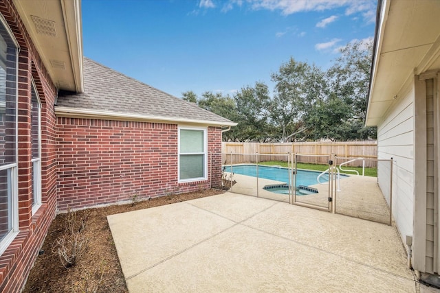 view of swimming pool featuring an in ground hot tub and a patio