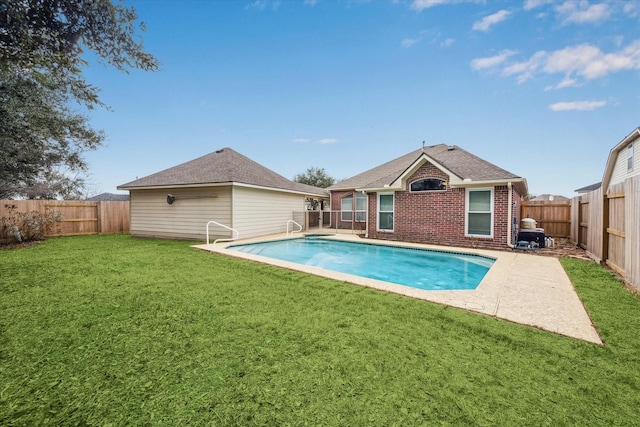 back of property featuring a fenced in pool and a lawn