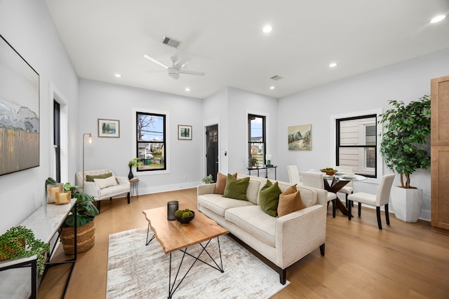 living area with a wealth of natural light, visible vents, and light wood finished floors