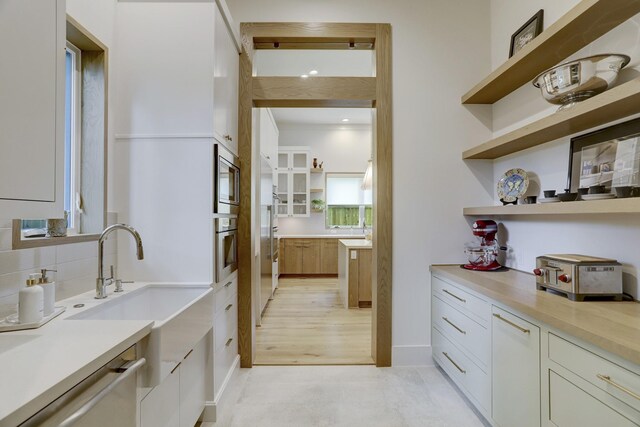 bar with white cabinetry, appliances with stainless steel finishes, sink, and backsplash