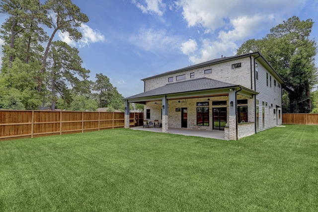 back of property featuring a yard and a patio