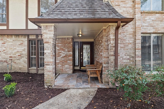 view of exterior entry with a patio area