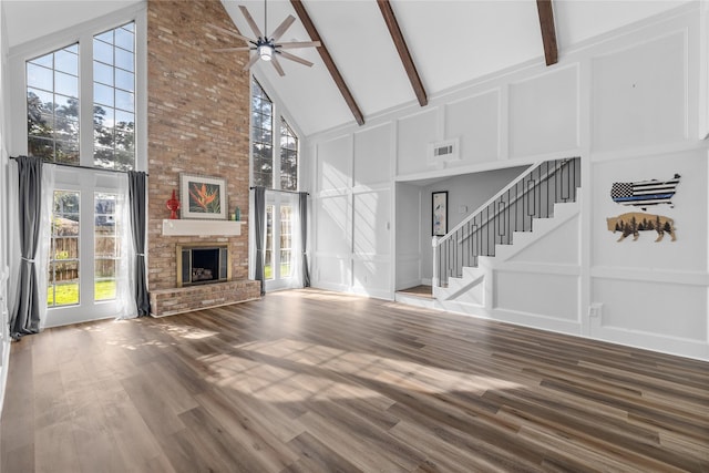 unfurnished living room with high vaulted ceiling, a fireplace, beamed ceiling, hardwood / wood-style flooring, and ceiling fan