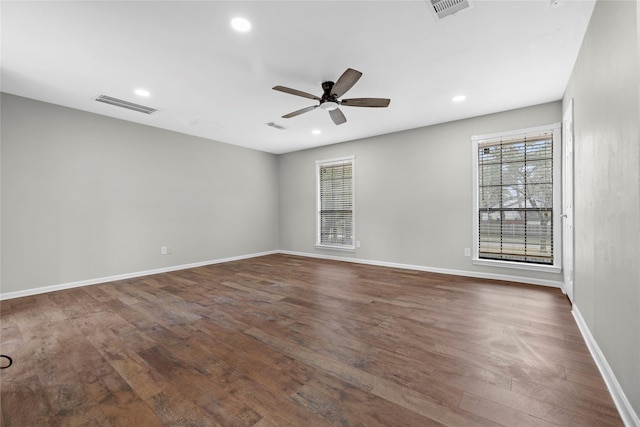 spare room with plenty of natural light, dark hardwood / wood-style floors, and ceiling fan