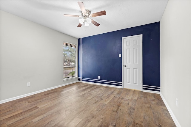 empty room with hardwood / wood-style flooring and ceiling fan