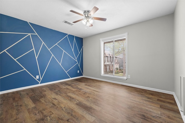 empty room featuring dark wood-type flooring and ceiling fan