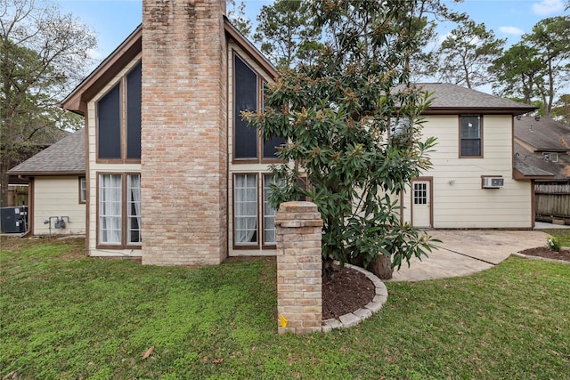 back of property featuring cooling unit, a yard, and a patio