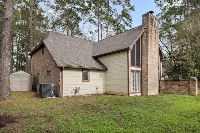 rear view of property featuring a yard, central AC, and a shed