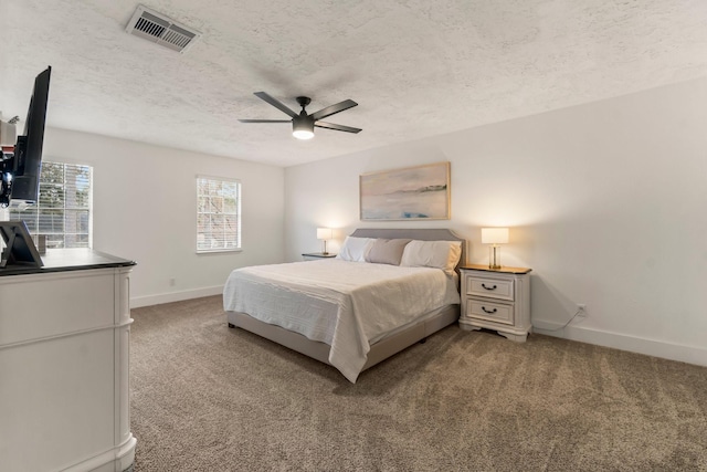 carpeted bedroom with ceiling fan and a textured ceiling