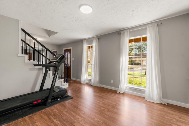 workout room with hardwood / wood-style floors and a textured ceiling