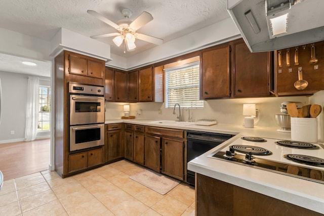 kitchen with double oven, ventilation hood, black dishwasher, sink, and plenty of natural light