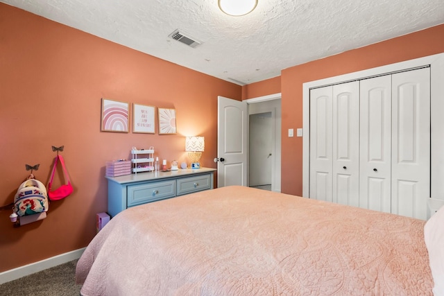 bedroom featuring dark colored carpet, a textured ceiling, and a closet