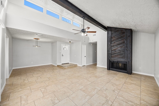 unfurnished living room with ceiling fan, high vaulted ceiling, a large fireplace, a textured ceiling, and beamed ceiling