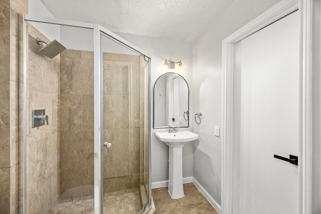 bathroom with tile patterned flooring, an enclosed shower, and a textured ceiling