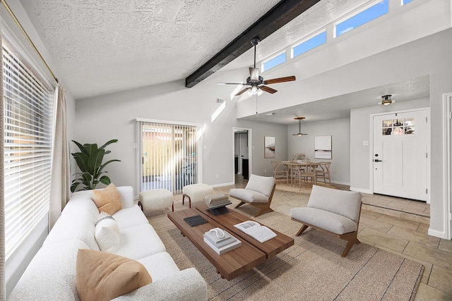 living room with beamed ceiling, ceiling fan, a healthy amount of sunlight, and a textured ceiling