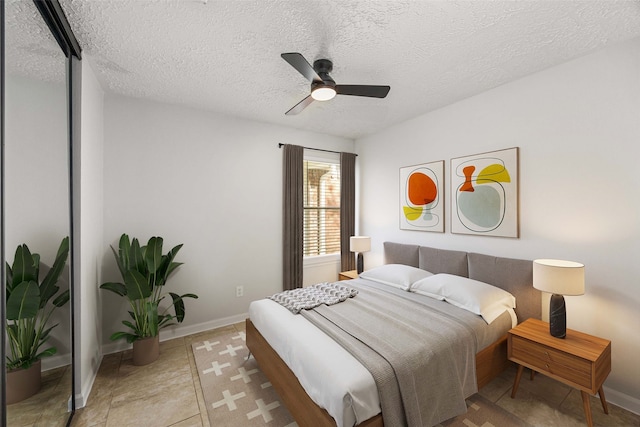 bedroom with ceiling fan and a textured ceiling