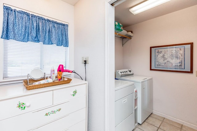 clothes washing area with light tile patterned floors and washer and clothes dryer