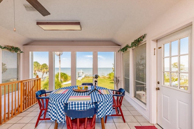 sunroom / solarium with a water view, vaulted ceiling, and a wealth of natural light