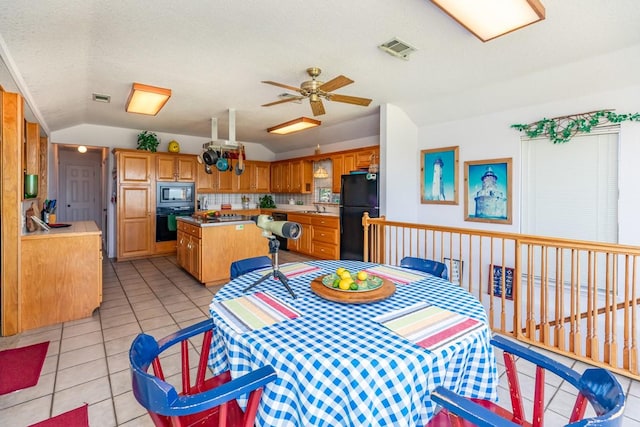 tiled dining area featuring ceiling fan, lofted ceiling, sink, and a textured ceiling