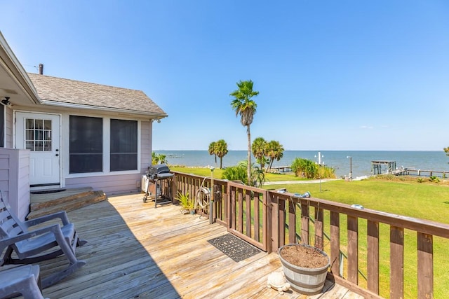 wooden terrace featuring a water view, grilling area, and a lawn