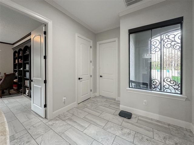 entrance foyer featuring marble finish floor, baseboards, visible vents, and ornamental molding