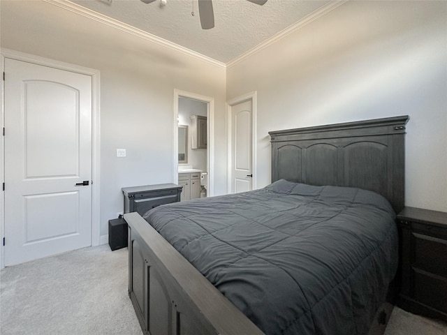 bedroom with a ceiling fan, light colored carpet, ensuite bath, a textured ceiling, and crown molding