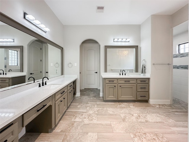 bathroom with a sink, two vanities, visible vents, and baseboards