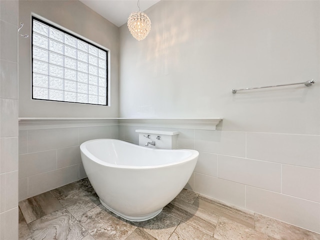 full bathroom with a freestanding bath, a wainscoted wall, and tile walls