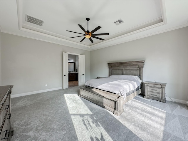 carpeted bedroom featuring a raised ceiling, crown molding, ceiling fan, and ensuite bath