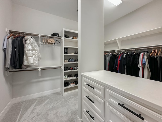 walk in closet with light carpet