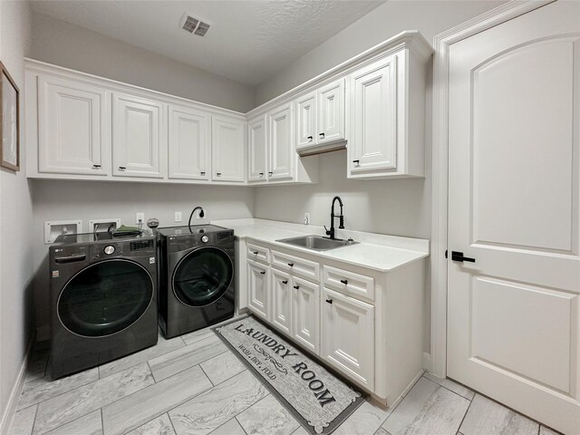 laundry room with cabinets, sink, a textured ceiling, and independent washer and dryer