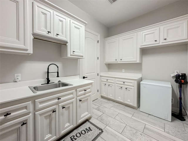 laundry area with marble finish floor, visible vents, and a sink