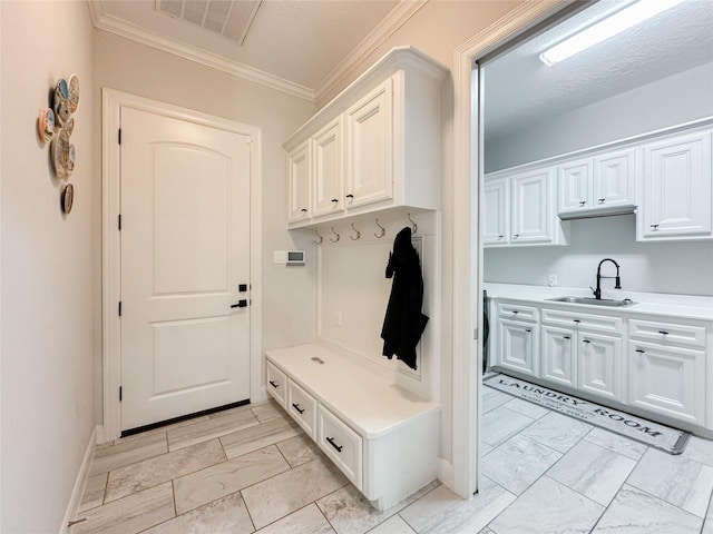 mudroom with ornamental molding, marble finish floor, visible vents, and a sink