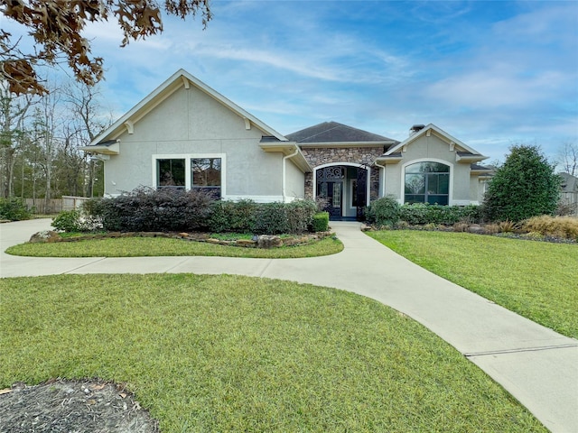 single story home featuring stone siding, a front lawn, and stucco siding