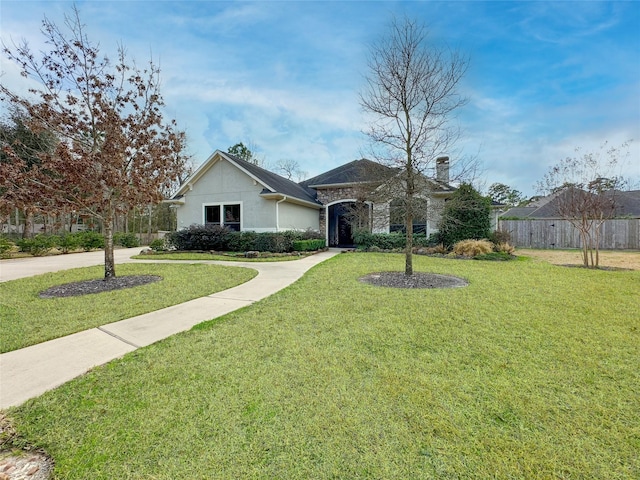 ranch-style house featuring stucco siding, fence, and a front yard