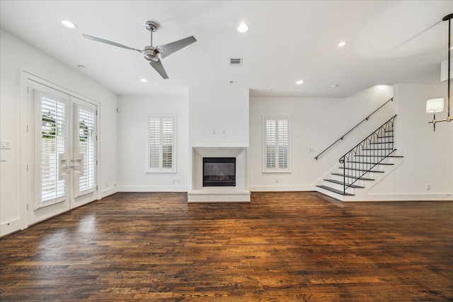 unfurnished living room with dark wood-type flooring, ceiling fan, and french doors