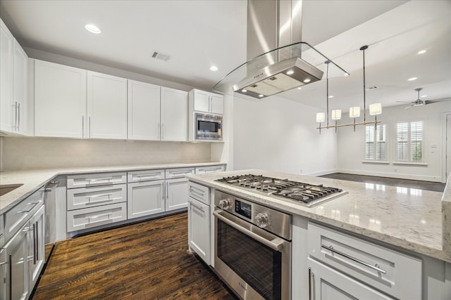 kitchen featuring stainless steel appliances, island range hood, white cabinets, and decorative light fixtures