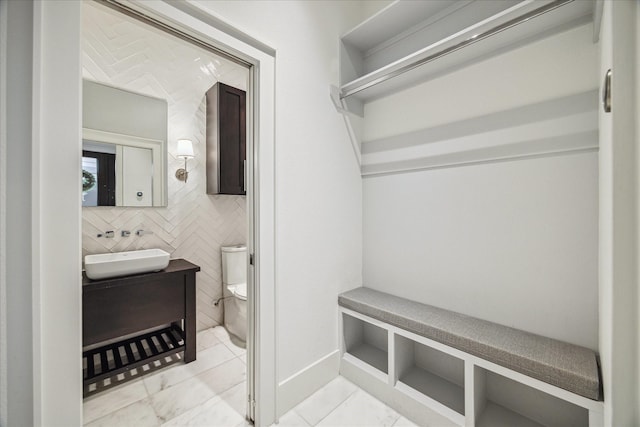 bathroom with vanity, tile patterned floors, tile walls, and toilet