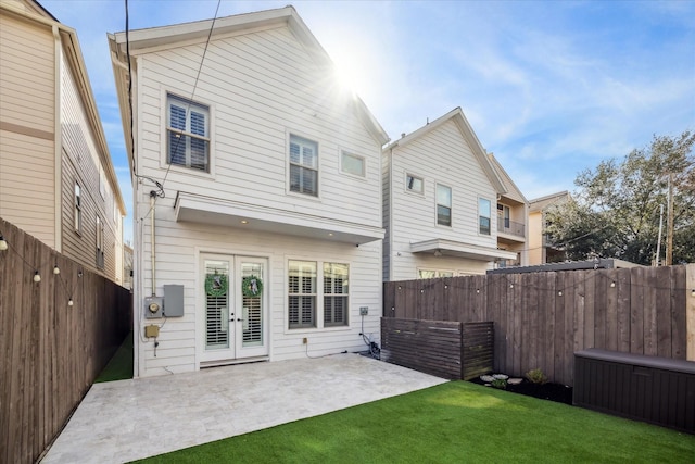 back of property featuring a lawn, a patio, and french doors