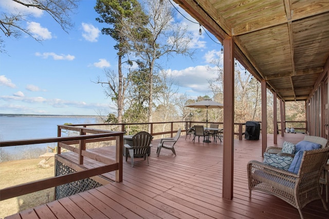 wooden deck featuring outdoor dining space and a water view