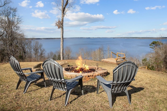 view of yard featuring a water view and a fire pit