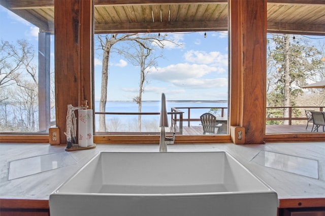 interior details with a water view, light countertops, and a sink