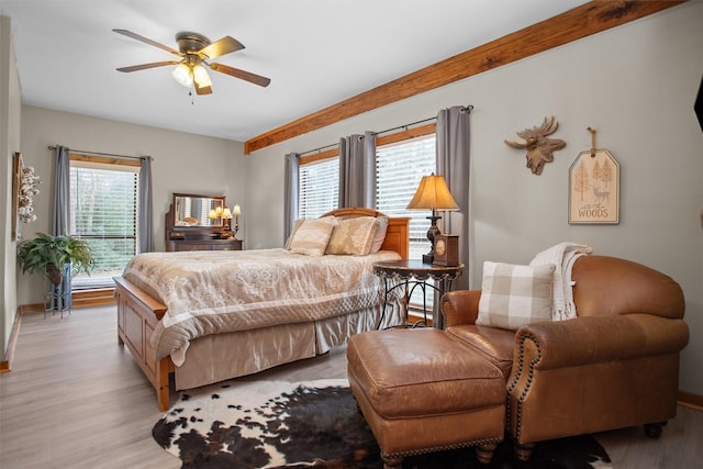 bedroom with a ceiling fan, light wood-style flooring, and baseboards